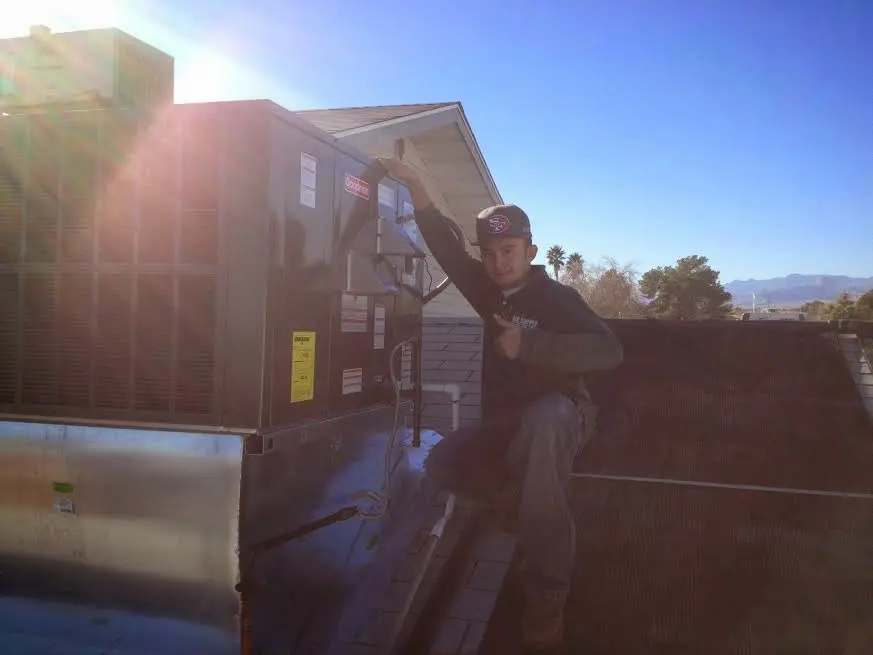 HVAC technician performing HVAC Inspection on a rooftop unit in White Oak
